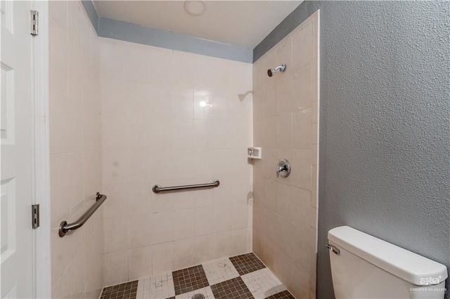 bathroom featuring toilet and tiled shower