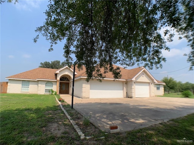 9401 N Fm 1015, Mercedes, TX 78570 - view of front facade with concrete driveway, a garage, a front lawn, brick siding, and a shingled roof