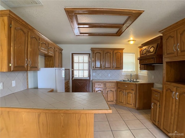 9401 N Fm 1015, Mercedes, TX 78570 - kitchen featuring a sink, a peninsula, backsplash, tile countertops, and healthy amount of natural light