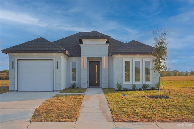 prairie-style house featuring a front lawn and a garage