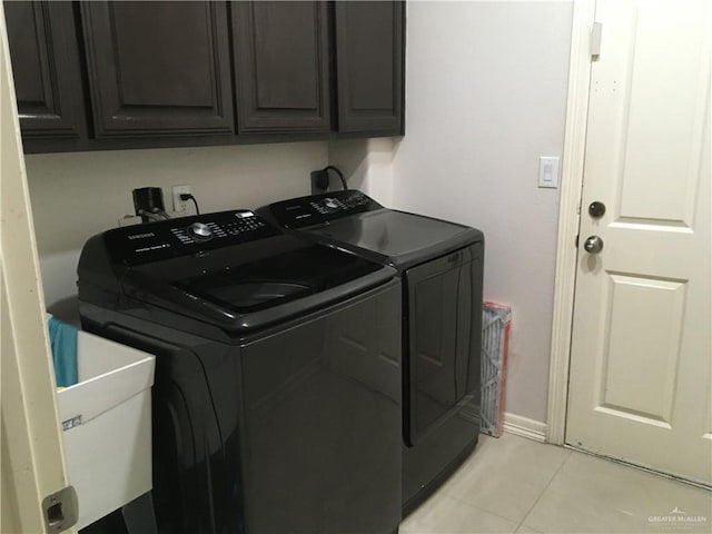 laundry area with washer and clothes dryer, light tile patterned floors, cabinet space, a sink, and baseboards