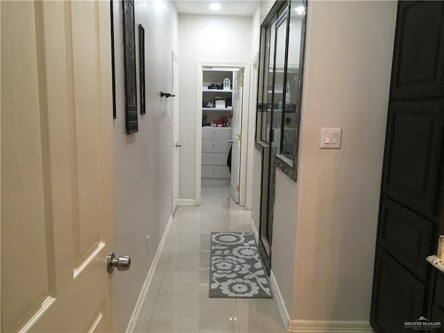 hall with light tile patterned floors and baseboards