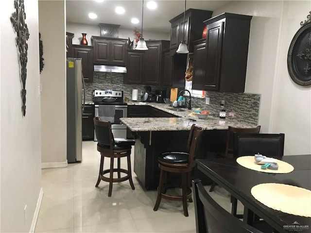 kitchen featuring extractor fan, stainless steel appliances, a peninsula, a sink, and tasteful backsplash