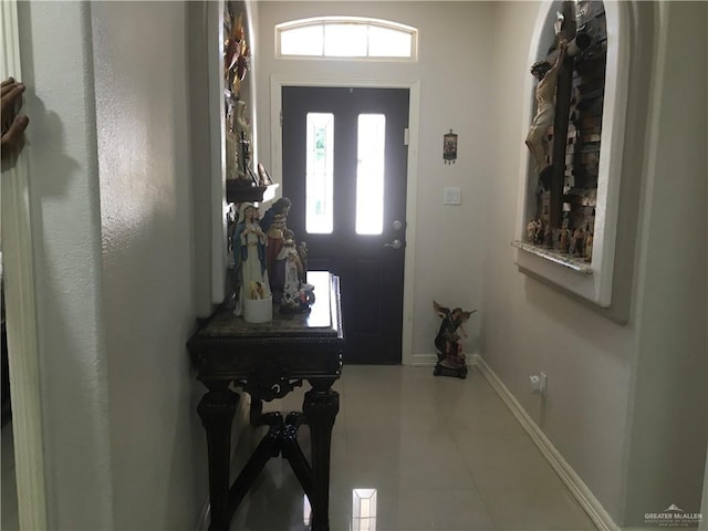 tiled entryway with a wealth of natural light and baseboards