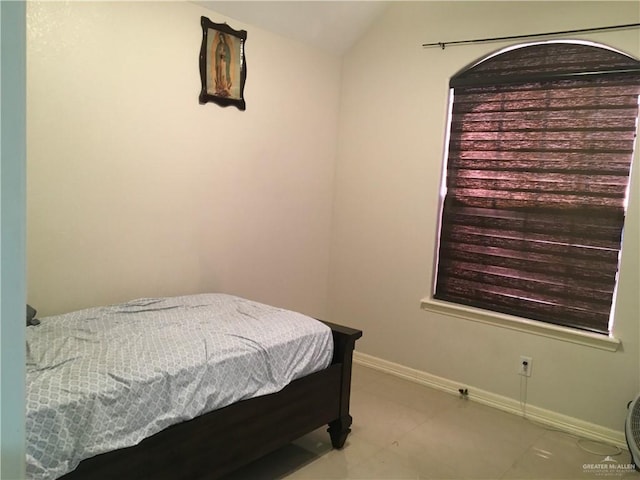 bedroom featuring vaulted ceiling and baseboards