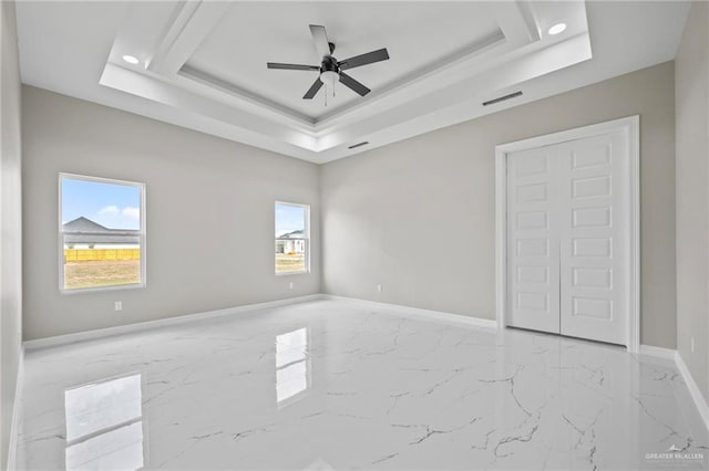 unfurnished bedroom with a tray ceiling and ceiling fan