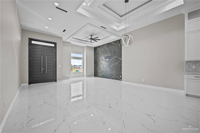 entrance foyer with ceiling fan and a tray ceiling