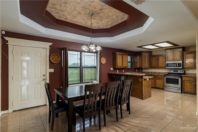 dining area featuring a tray ceiling and an inviting chandelier