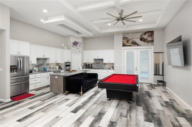 kitchen with french doors, a towering ceiling, decorative backsplash, coffered ceiling, and stainless steel fridge with ice dispenser