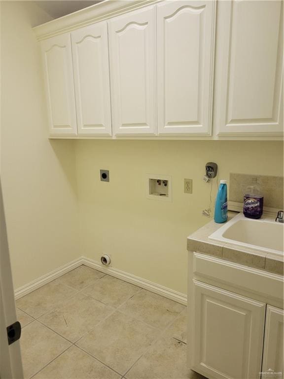 laundry room featuring sink, cabinets, hookup for an electric dryer, hookup for a washing machine, and light tile patterned flooring