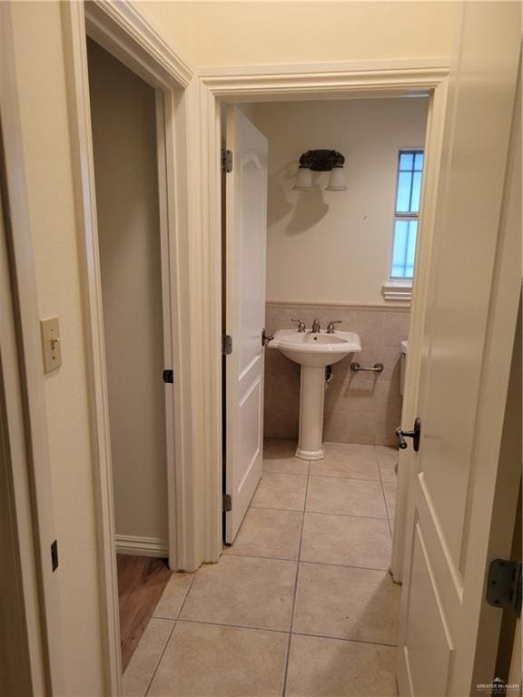 bathroom with tile patterned flooring, tile walls, and sink