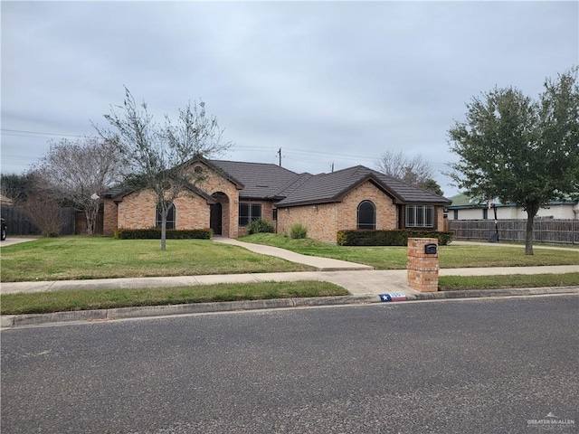 ranch-style home featuring a front lawn