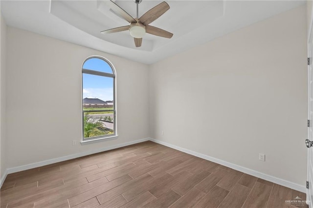 spare room with a raised ceiling and ceiling fan