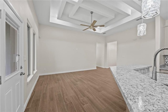 living room featuring a raised ceiling and ceiling fan