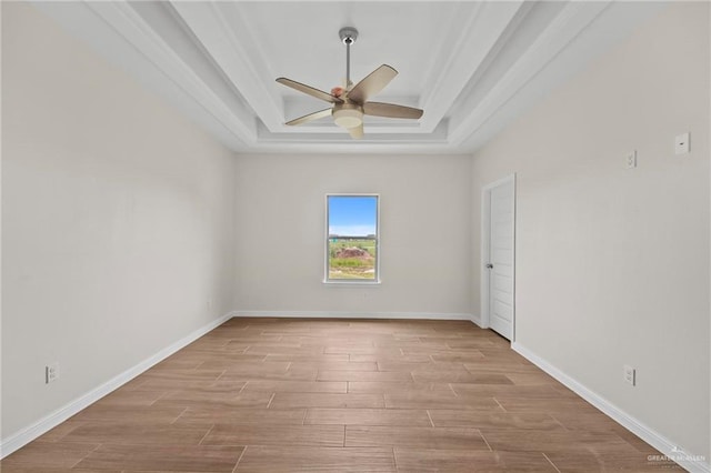 spare room featuring a tray ceiling and ceiling fan