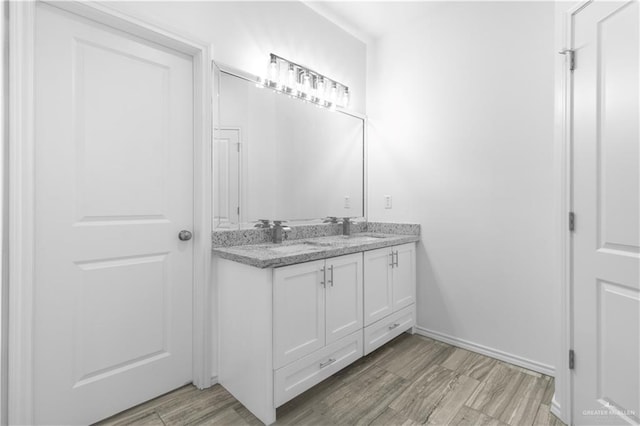 3804 Crimson Ave, Mission, TX 78574 - bathroom featuring a sink, baseboards, double vanity, and wood finished floors