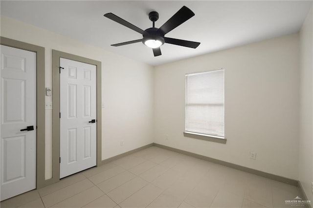 tiled spare room featuring ceiling fan