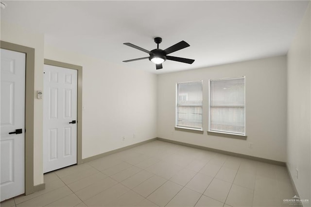 spare room featuring ceiling fan and light tile patterned flooring