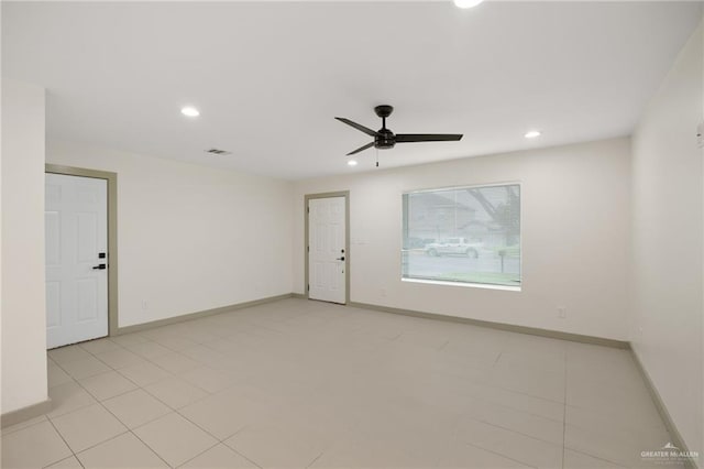 tiled spare room with ceiling fan