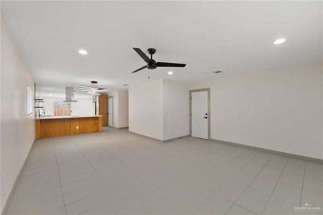 unfurnished living room featuring sink, ceiling fan, and light tile patterned flooring