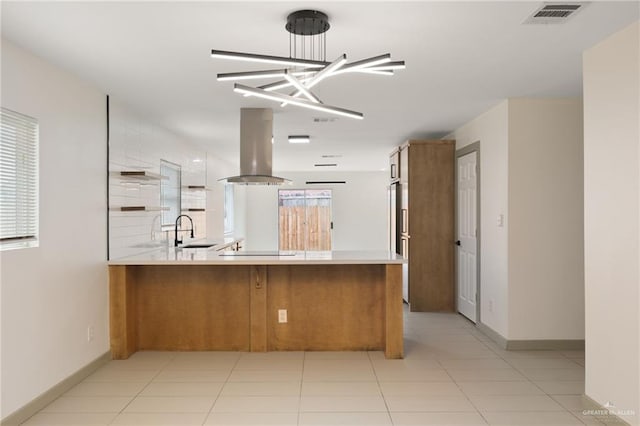 kitchen featuring kitchen peninsula, extractor fan, sink, light tile patterned floors, and an inviting chandelier