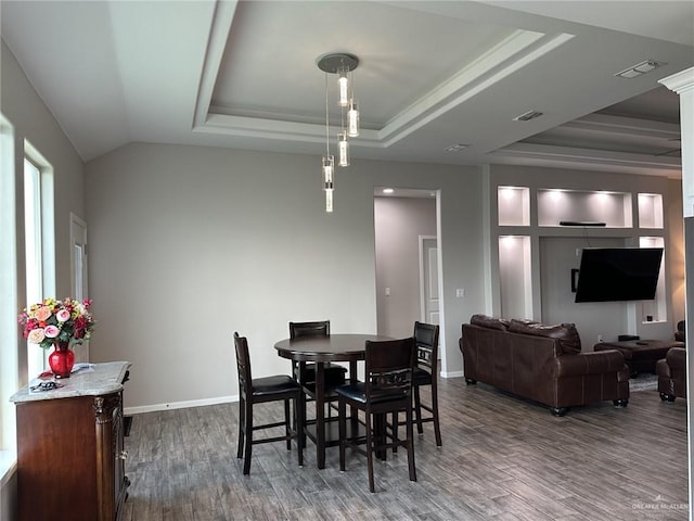 dining room with wood-type flooring and a tray ceiling