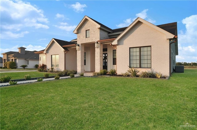 view of front of property with central AC unit and a front yard