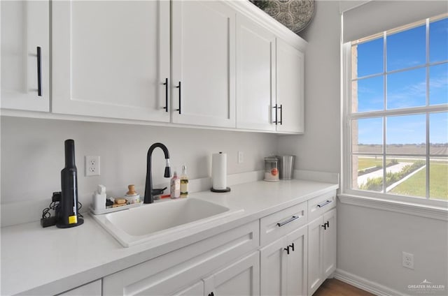 bar with white cabinets and sink