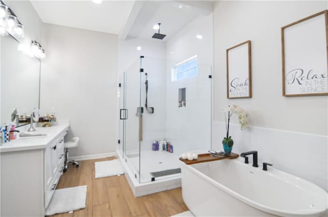 bathroom featuring plus walk in shower, vanity, and hardwood / wood-style flooring