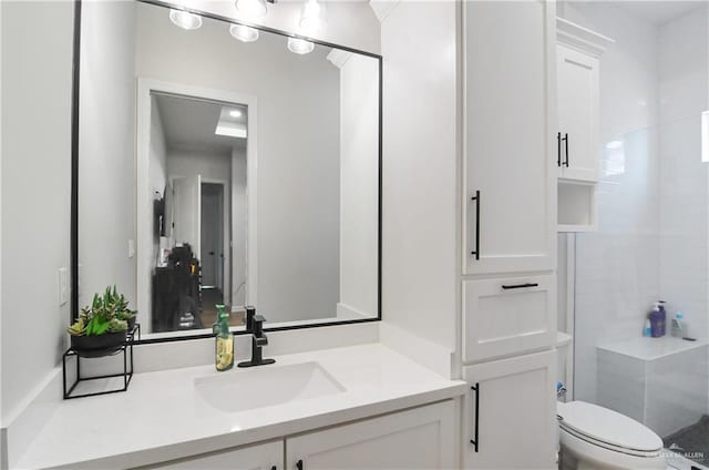 bathroom with vanity, toilet, and a shower with door