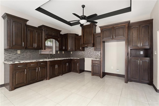 kitchen with ceiling fan, sink, backsplash, dark brown cabinets, and light tile patterned floors