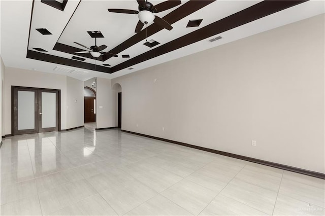 spare room featuring ceiling fan, a raised ceiling, and light tile patterned floors