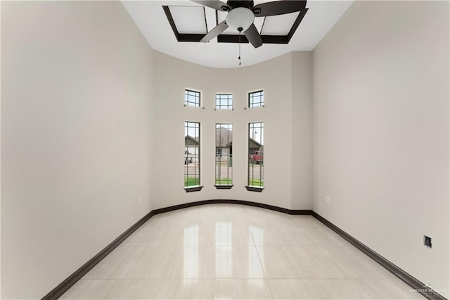 tiled empty room featuring ceiling fan