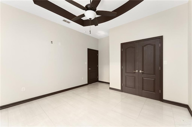 unfurnished bedroom with ceiling fan, light tile patterned flooring, and a closet