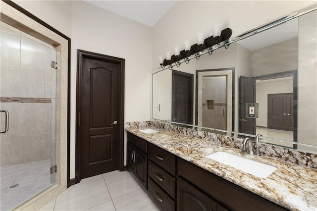 bathroom with tile patterned flooring, vanity, and walk in shower