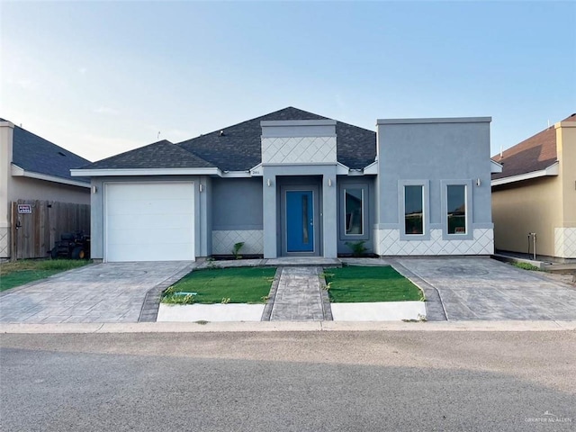 2411 King David Dr, Rio Grande City, TX 78582 - contemporary home featuring a shingled roof, a garage, driveway, and stucco siding