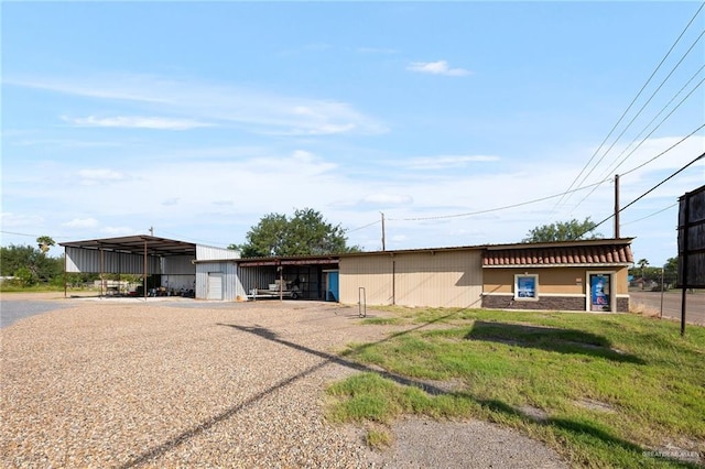 ranch-style home with an outbuilding and a front lawn