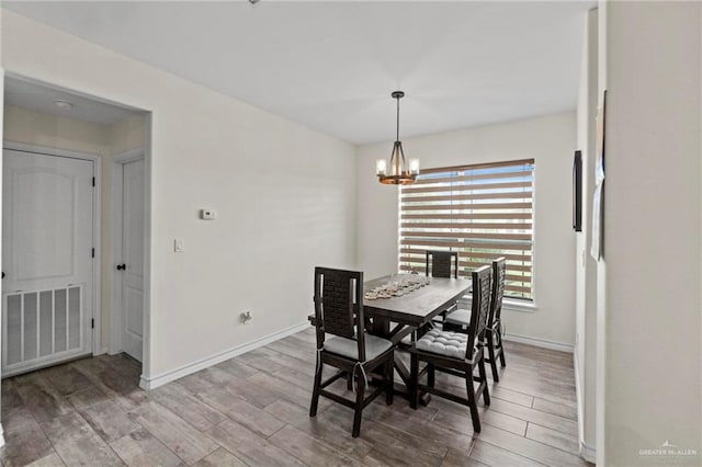 dining space featuring wood-type flooring and a chandelier