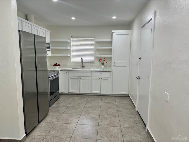 808 Tennessee Ave, Weslaco, TX 78596 - kitchen featuring appliances with stainless steel finishes, open shelves, light countertops, white cabinetry, and light tile patterned floors