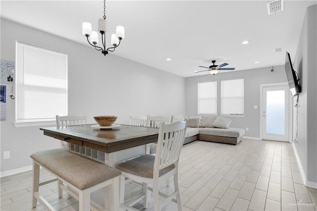 dining space featuring ceiling fan with notable chandelier and light hardwood / wood-style floors