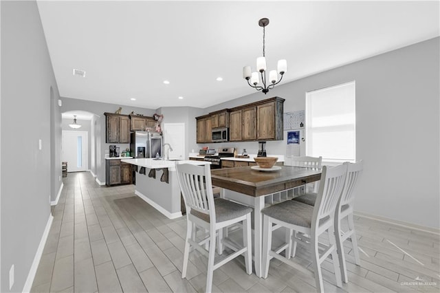 dining space featuring sink and a notable chandelier