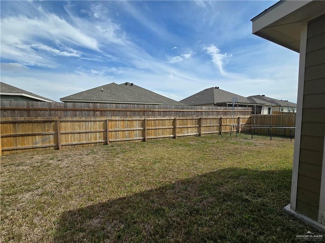 view of yard featuring a fenced backyard and a trampoline