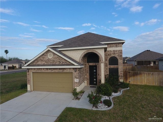 view of front facade featuring a garage, brick siding, fence, concrete driveway, and a front yard