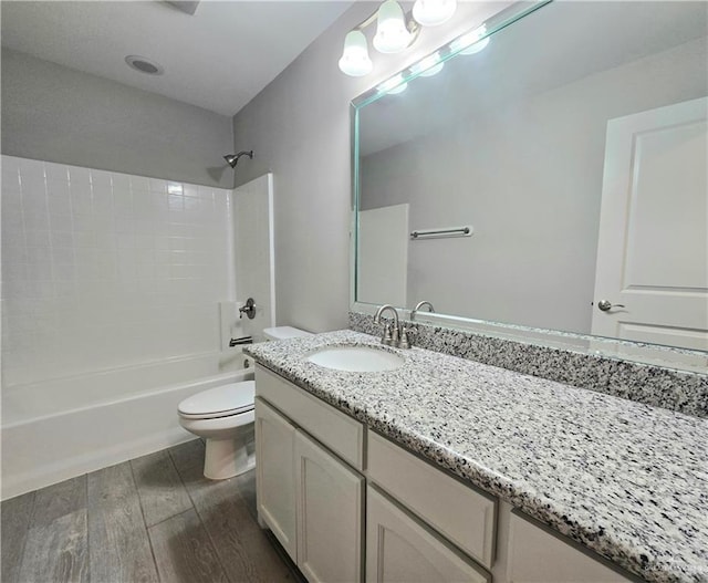 bathroom with toilet, shower / washtub combination, wood finished floors, and vanity