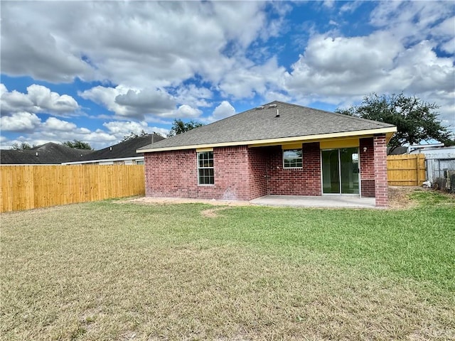 rear view of house featuring a lawn and a patio area