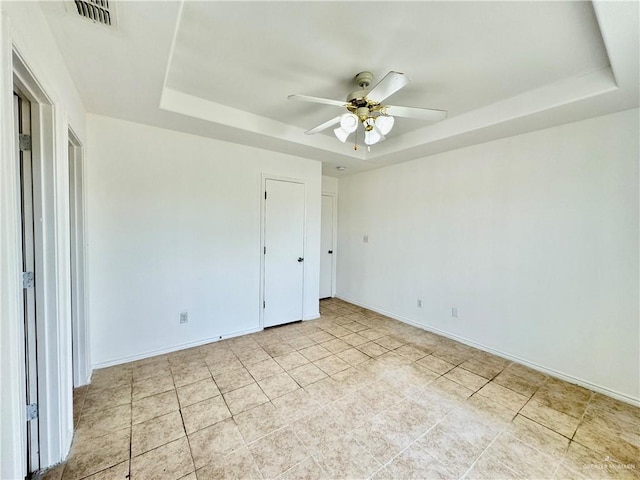 unfurnished bedroom featuring a tray ceiling and ceiling fan