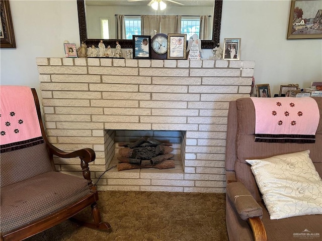 sitting room featuring ceiling fan, carpet floors, and a brick fireplace