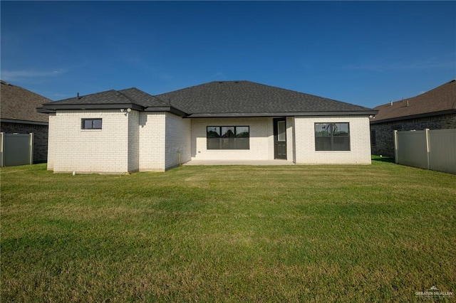rear view of property with a yard, a fenced backyard, and brick siding