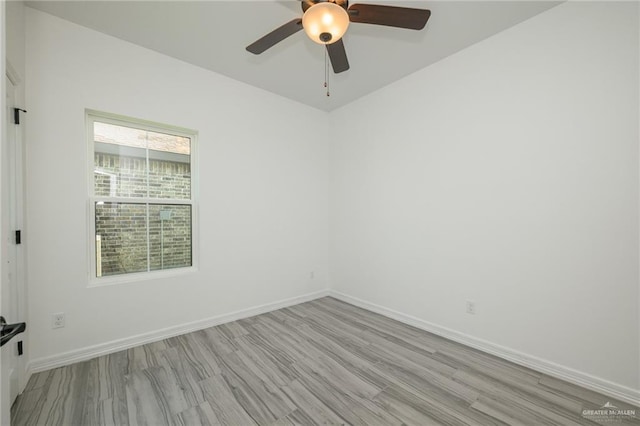 spare room with light wood-style floors, ceiling fan, and baseboards