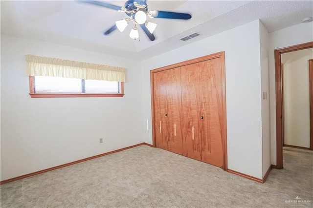 unfurnished bedroom with ceiling fan, a closet, and light colored carpet